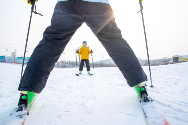 滑雪场上面对面滑雪的快乐父子图片下载