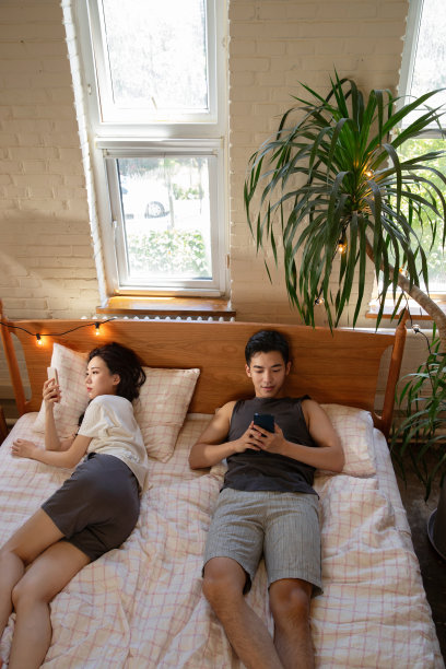 青年夫妇坐在床上生闷气图片下载