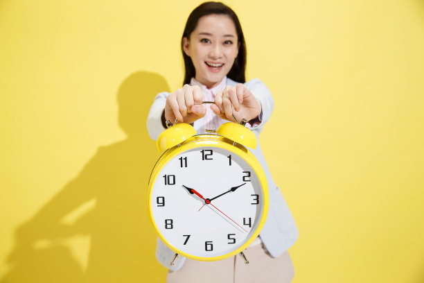 青年商务女士拿着钟表图片下载