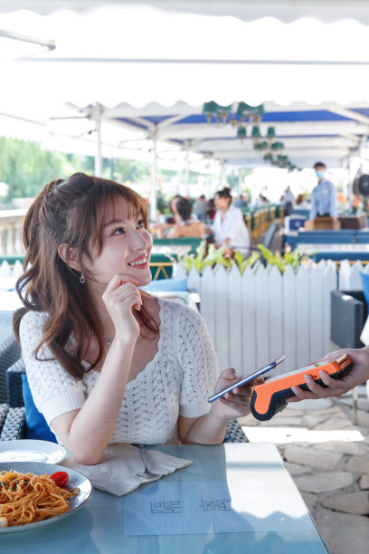 年轻女人在餐厅用手机付款图片下载