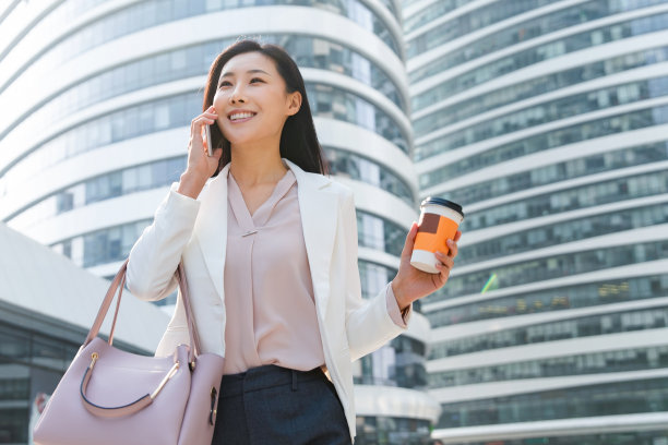 拿着咖啡的商务女性打电话素材图片