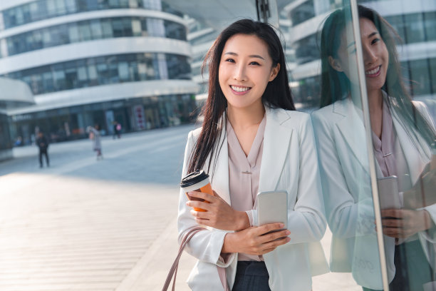 站在户外拿着咖啡的商务女性图片下载