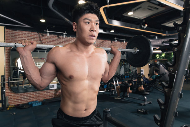 年轻男子在健身房练习举杠铃图片下载