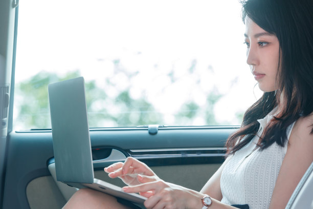 商务女性在汽车内使用电脑图片下载
