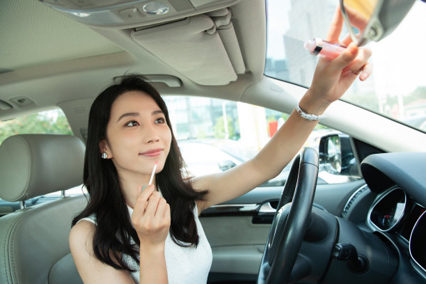 青年女人坐在车里化妆图片下载