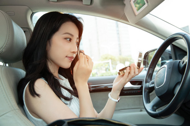 青年女人坐在车里化妆图片下载