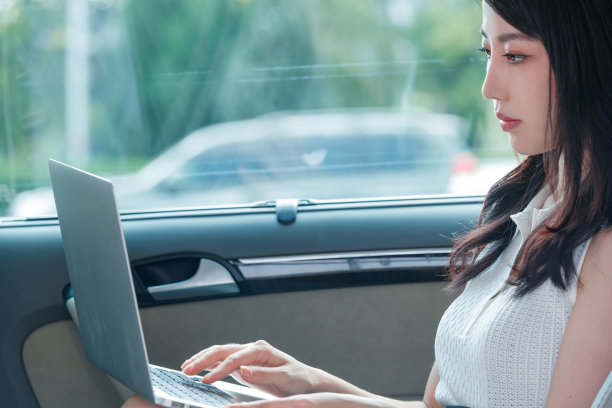 商务女性在汽车内使用笔记本电脑图片下载