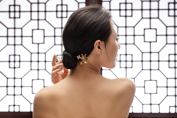 正在调整发髻中簪子的东方女人图片下载