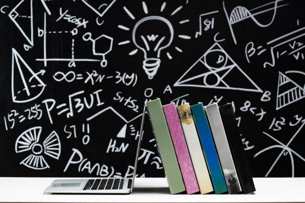 黑板画前的桌子上的书和笔记本电脑图片下载