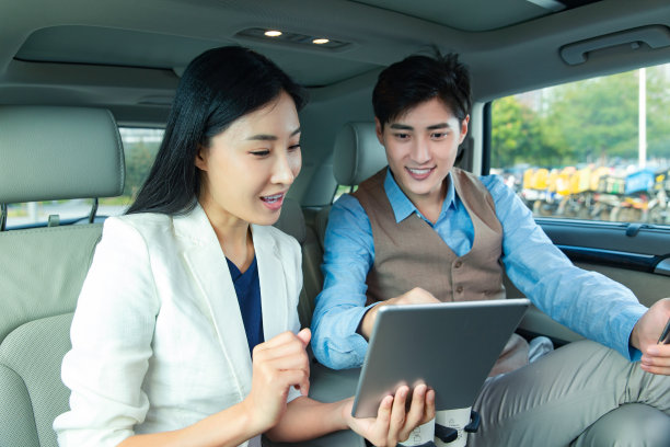 商务人士在汽车里看平板电脑图片下载