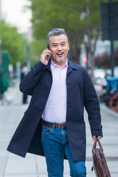 户外拎着公文包打电话的商务中老年男子图片下载