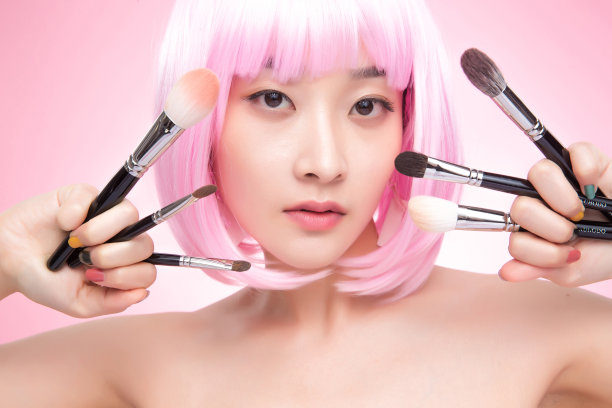 手指夹满化妆刷的年轻女孩图片下载