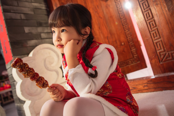 拿着糖葫芦思考的小女孩图片下载