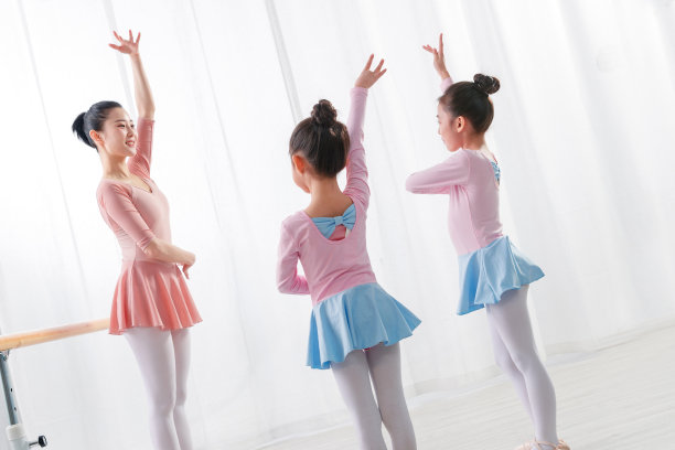 年轻舞蹈老师教小女孩们跳舞图片下载