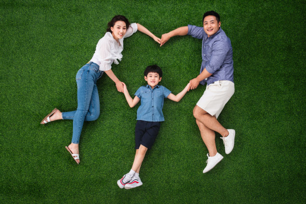 一家三口在草地上摆成心形图片下载