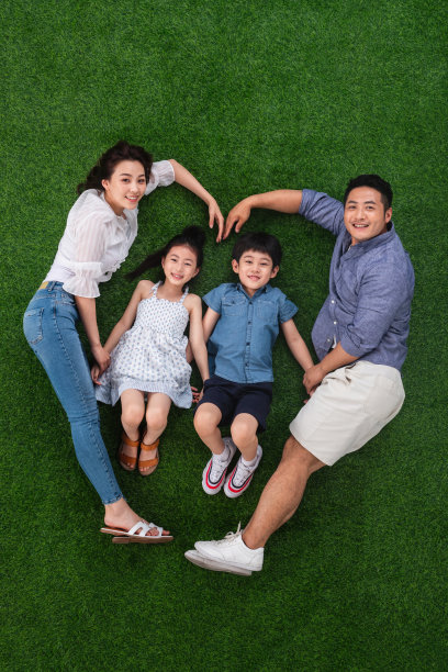 幸福的四口之家躺在草地上组成心形图片下载