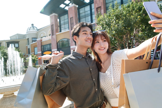 逛街的幸福情侣用手机拍照图片下载