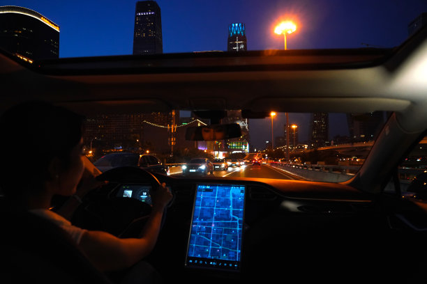 夜晚按屏幕地图开车的青年女人图片下载