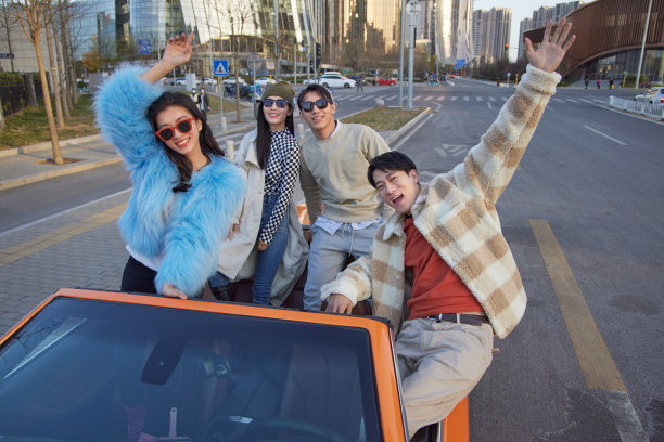 快乐的青年人驾驶跑车出行图片下载