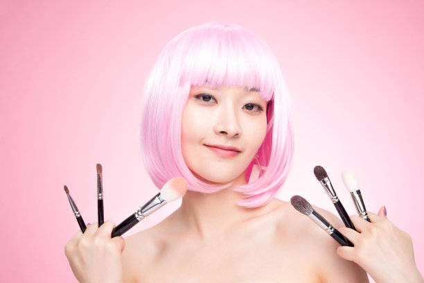 手指夹满化妆刷的年轻女孩图片下载