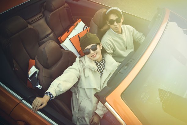 快乐的青年情侣驾驶跑车出行图片下载