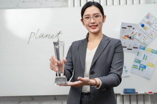 成功的商务女士拿着奖杯图片下载