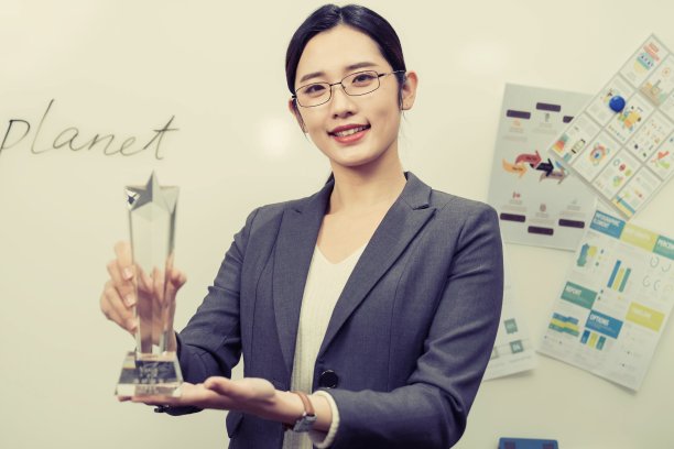 成功的商务女士拿着奖杯图片下载