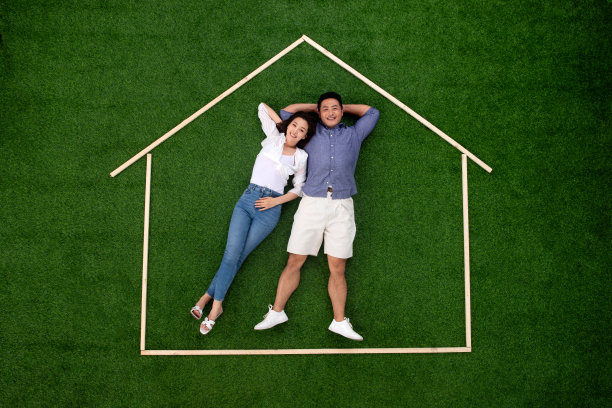 青年伴侣躺在草地上的房子轮廓里图片下载