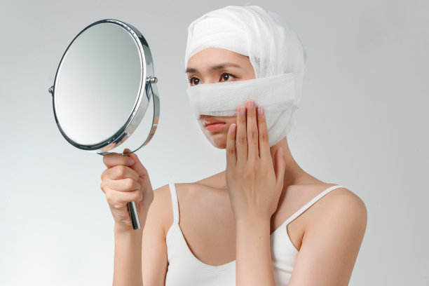 做整形手术的青年女人照镜子图片下载