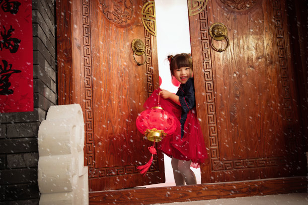 漂亮的小女孩手提红灯笼庆祝新年图片下载