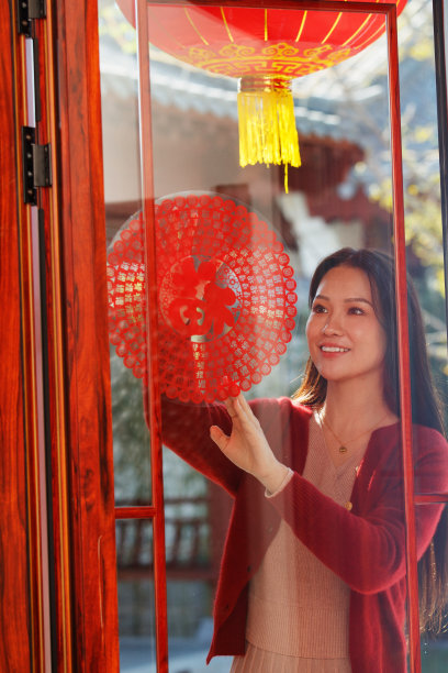 年轻女人过年贴窗花图片下载