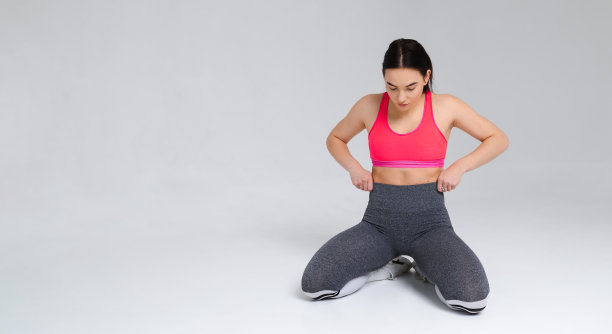 美丽的女孩在运动服装摆姿势在白色的工作室背景图片下载