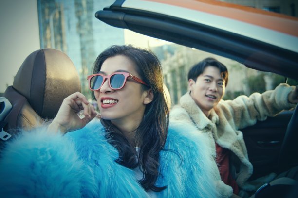 快乐的青年情侣驾驶跑车出行图片下载