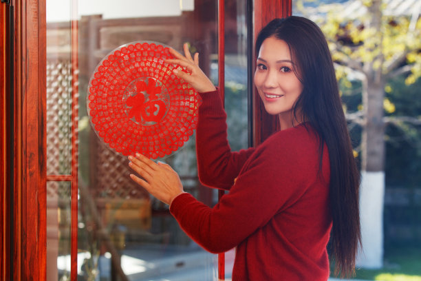 年轻女人过年贴窗花图片下载