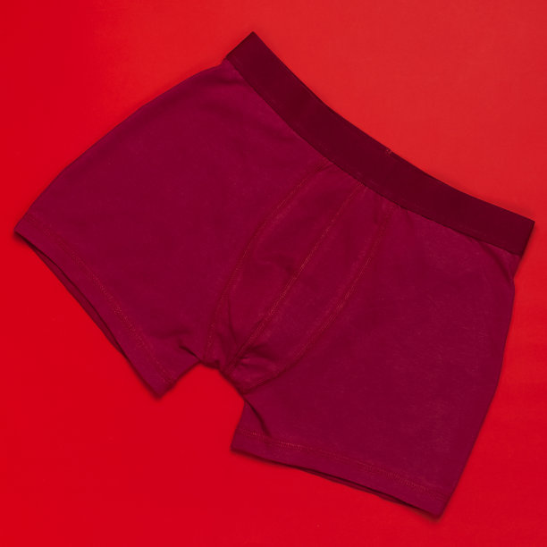 男士内裤，红色紫红色内裤在红色背景平躺顶视图复制空间。时尚博客，天然内衣，广告，购物理念。裤子拳击手图片下载
