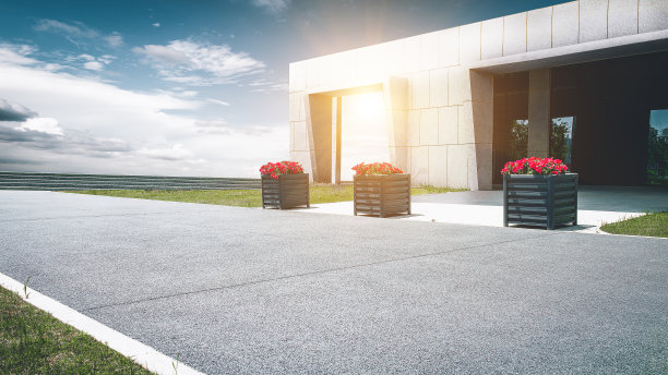 在晴朗的天空下，柏油路前矗立着现代化的建筑图片下载