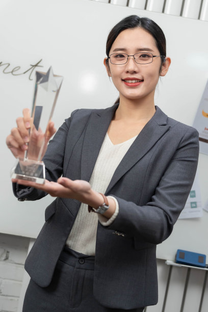 成功的商务女士拿着奖杯图片下载
