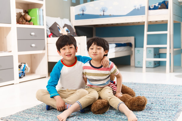 两个男孩坐在卧室的地毯上图片下载
