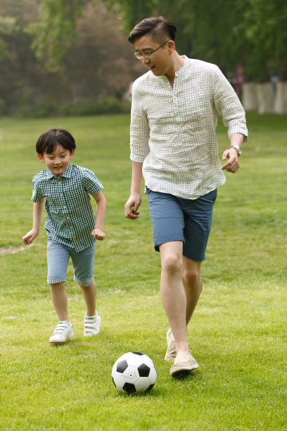 快乐父子在草地上踢足球图片下载