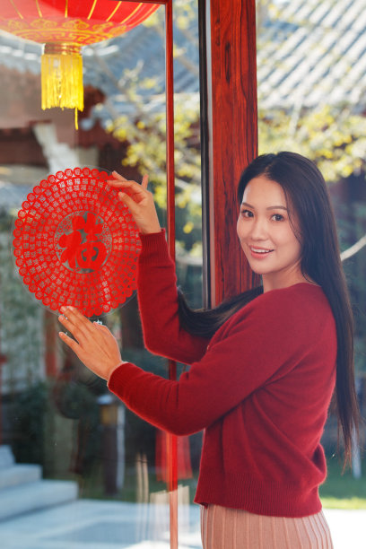 年轻女人过年贴窗花图片下载