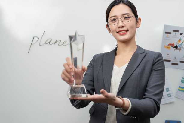 成功的商务女士拿着奖杯图片下载