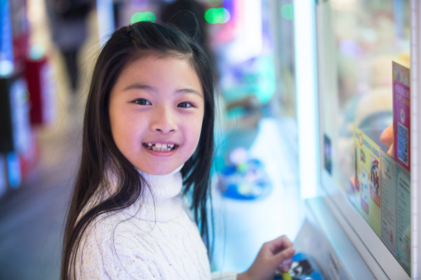 可爱的女孩在游戏厅玩耍图片下载