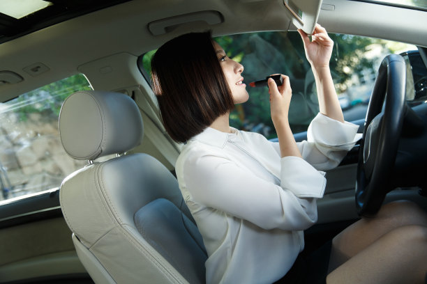 青年女人坐在车里化妆图片下载