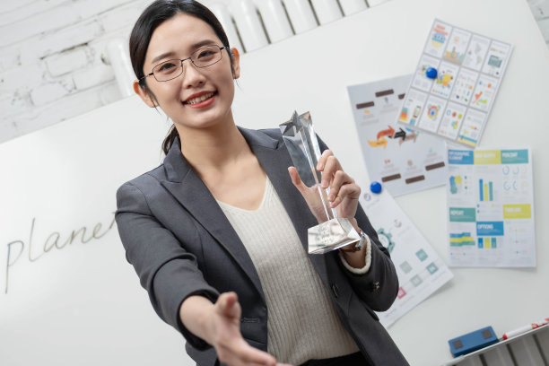 成功的商务女士拿着奖杯图片下载