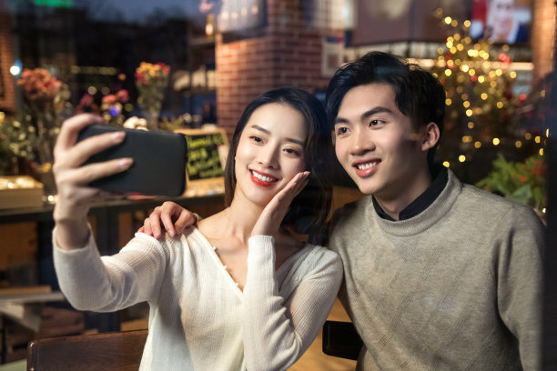 餐厅内的青年伴侣使用手机自拍图片下载