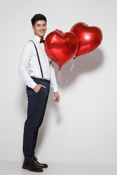 青年男人拿着心形气球图片下载