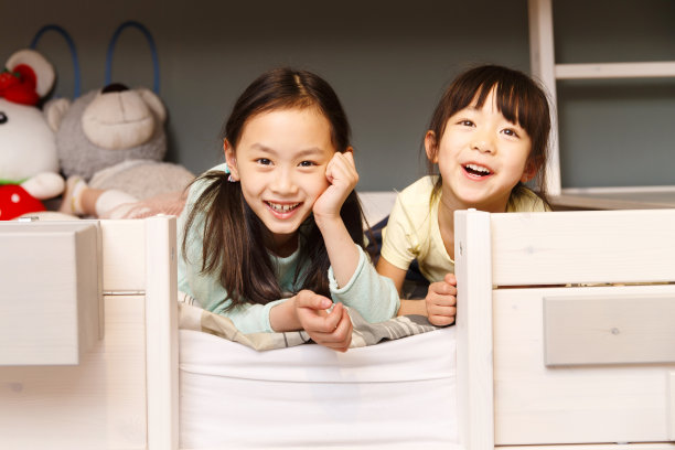 可爱的小女孩在床上玩耍图片下载