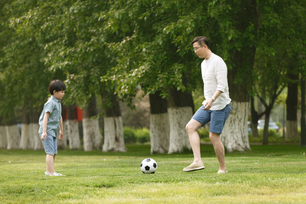 快乐父子在草地上踢足球图片下载
