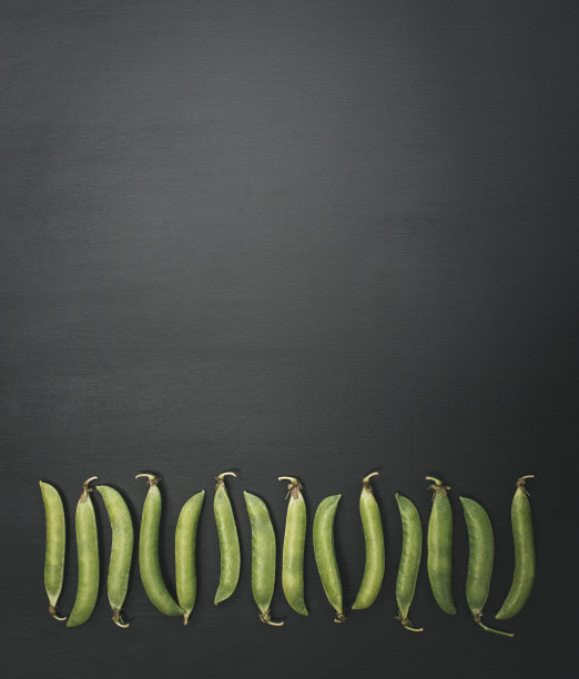 木桌上的新鲜青豆。素食食物。豆荚里的绿豌豆种子。新鲜绿豌豆的特写。平的。前视图。图片下载