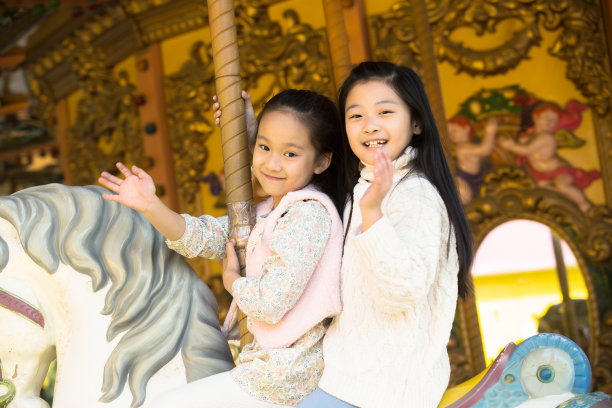 两个小女孩在玩旋转木马图片下载
